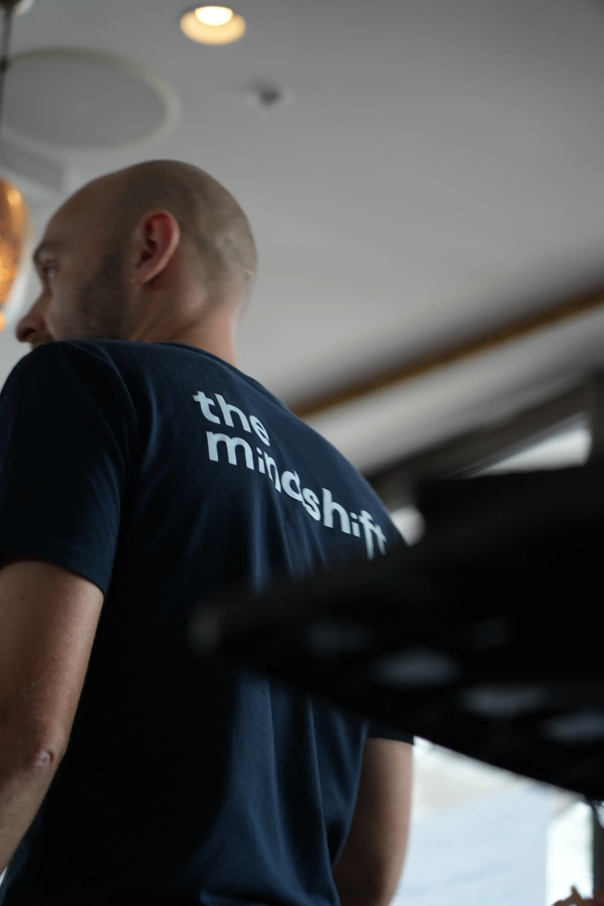 Steve Morris speaking with a group, wearing a The Mindshift Lab shirt